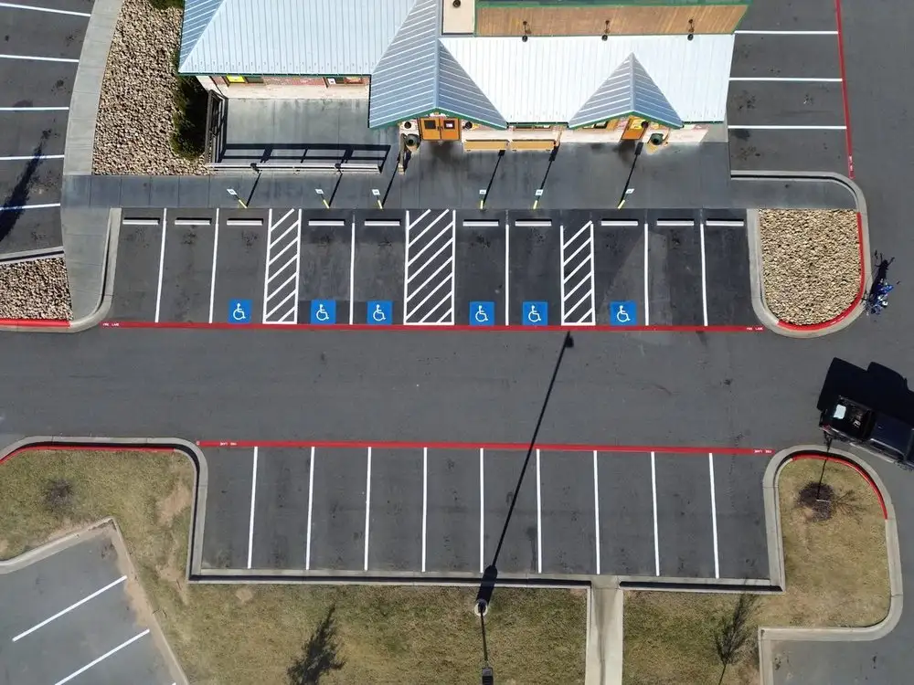 Aerial view of a freshly striped lot with a red fire lane running along the building frontage