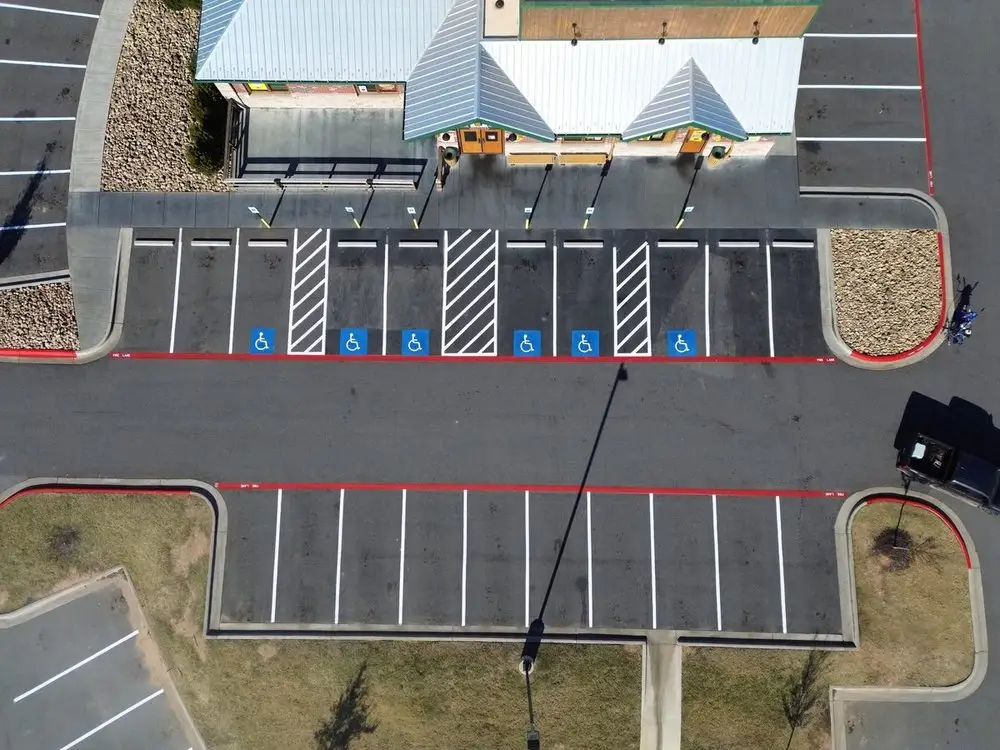 Aerial view of a freshly striped lot with a red fire lane running along the building frontage