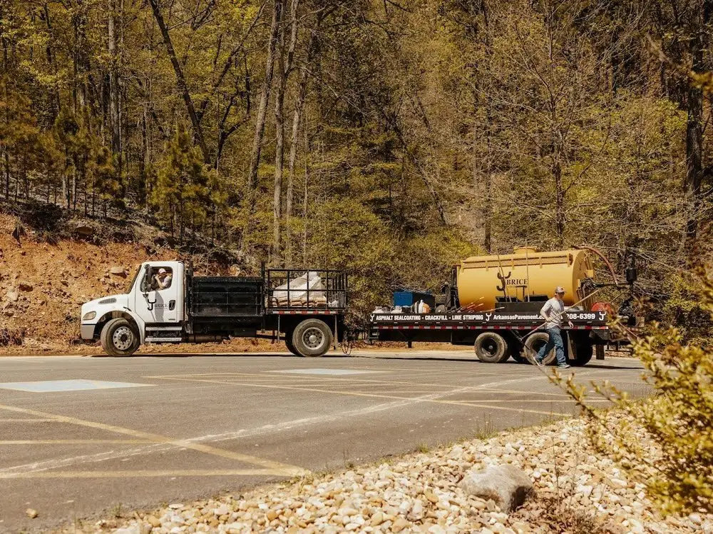 The sealcoat tank truck parked on site with the hose run out